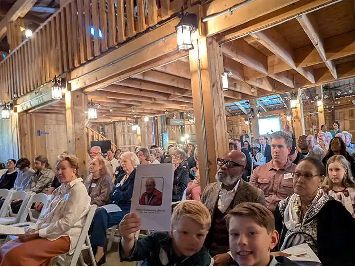 event celebration of life Geoffrey C Morell celebrants seated in barn